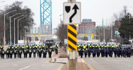 Policías canadienses avanzan para desalojar a manifestantes que bloquearon el acceso al Puente Ambassador, que une a Estados Unidos con Canadá, en Windsor, Ontario, el domingo 13 de febrero de 2022.