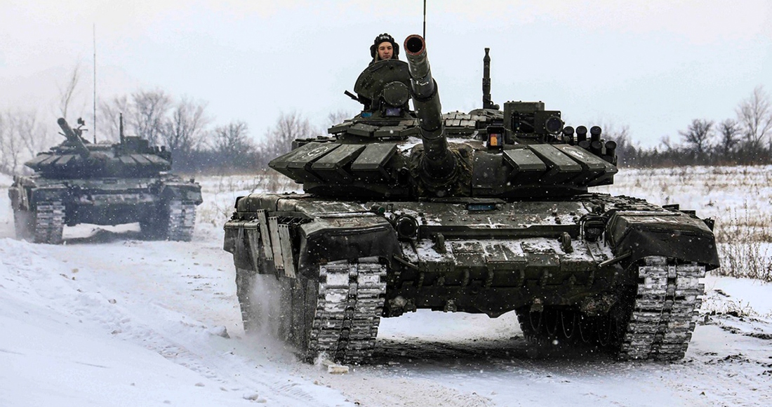 En esta foto distribuida por el Servicio de Prensa del Ministerio de Defensa ruso el 14 de febrero de 2022, tanques recorren un campo durante maniobras militares en la región de Leningrado, Rusia.