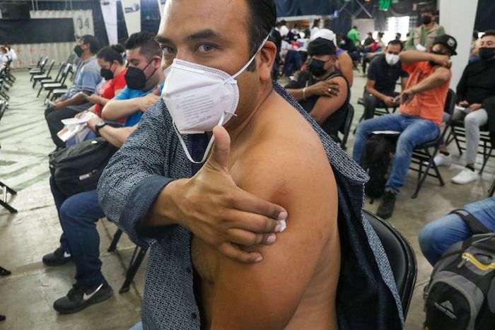 Adultos de 30 años en adelante acuden a vacunarse con su dosis de refuerzo contra la COVID-19 en el Palacio de los deportes.