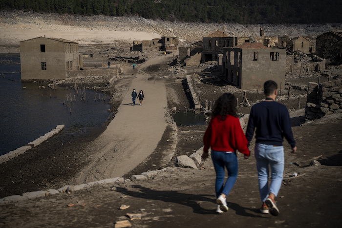 Visitantes caminando por el antiguo pueblo de Aceredo, reaparecido debido a la sequía en el embalse de Lindoso, en el noroeste de España, el viernes 11 de febrero de 2022.