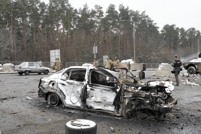 Soldados y voluntarios de las Fuerzas de Defensa Territorial de Ucrania, junto a un auto calcinado cerca de un puesto de control en Brovary, a las afueras de Kiev, Ucrania, el 1 de marzo de 2022.