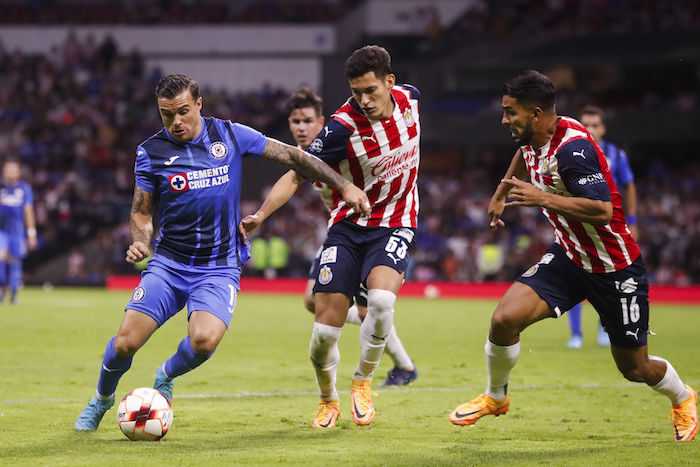 El jugador de Cruz Azul Christian Tabó (i) disputa el balón con Jesús Orozco (c) y con Miguel Ponce (d) de Chivas el sábado 16 de abril de 2022, durante un partido de la jornada 14 del Torneo Clausura del futbol mexicano realizado en el Estadio Azteca de la Ciudad de México.