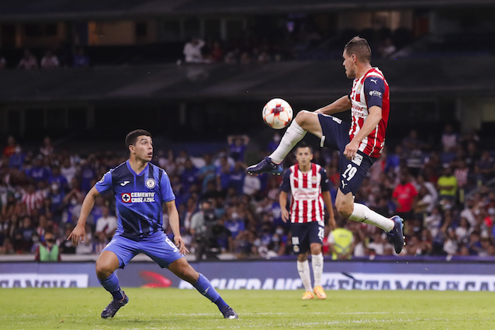 El jugador de Cruz Azul Erik Lira (i) disputa el balón con Alan Torres (d) de Chivas el sábado 16 de abril de 2022, durante un partido de la jornada 14 del Torneo Clausura del futbol mexicano realizado en el Estadio Azteca de la Ciudad de México.