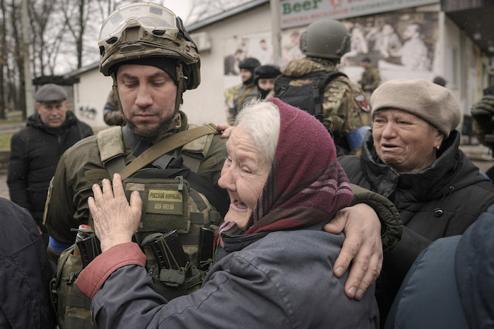 Una mujer abraza a un soldado ucraniano tras la llegada de un contingente militar y de vehículos con asistencia a Bucha, un suburbio de Kiev que estuvo ocupado por los rusos, en Ucrania, el sábado 2 de abril de 2022.