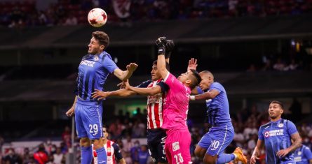 El jugador de Cruz Azul Santiago Giménez (i) disputa el balón con Gilberto Sepúlveda (2i) y con el portero Miguel Jiménez (c) de Chivas el sábado 16 de abril de 2022, durante un partido de la jornada 14 del Torneo Clausura del futbol mexicano realizado en el Estadio Azteca de la Ciudad de México.