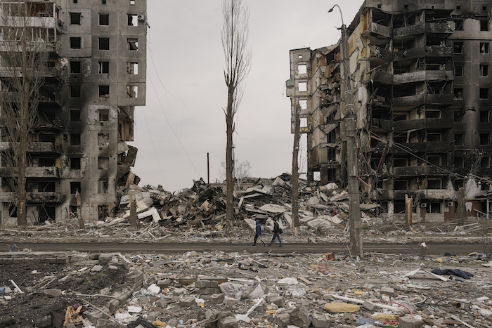 Unas personas caminan junto a un edificio de apartamentos destruido durante los combates entre las fuerzas ucranianas y rusas en Borodyanka, Ucrania, el martes 5 de abril de 2022.