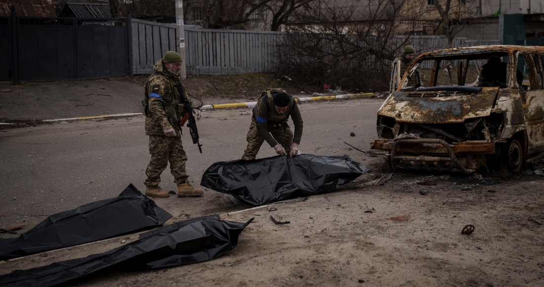 Soldados ucranianos recuperan del interior de un vehículo calcinado los restos de cuatro civiles muertos en Bucha, en las afueras de Kiev, Ucrania, el martes 5 de abril de 2022.