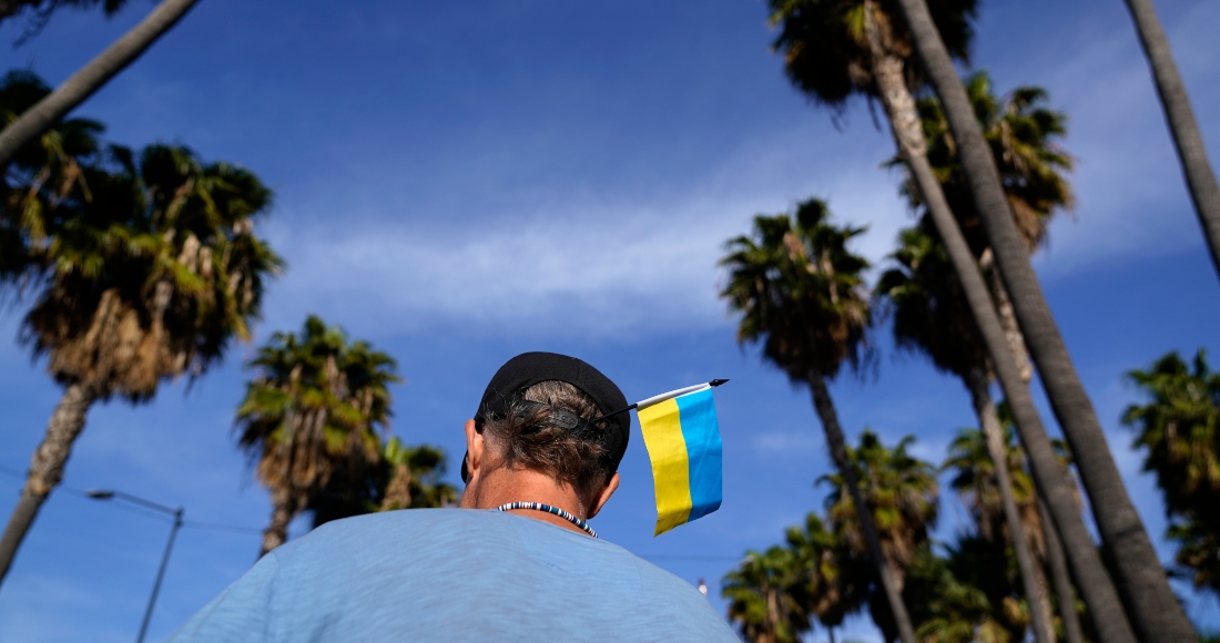 Zank Bennett, un voluntario de Estados Unidos, lleva una bandera de Ucrania en su gorra mientras ayuda a refugiados ucranianos que quieren solicitar asilo en su país, el 4 de abril de 2022, en Tijuana, México.