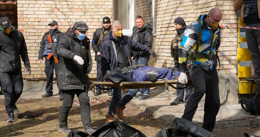 Un grupo de personas observa una fosa común el lunes 4 de abril de 2022, en Bucha, en las afueras de Kiev, Ucrania.