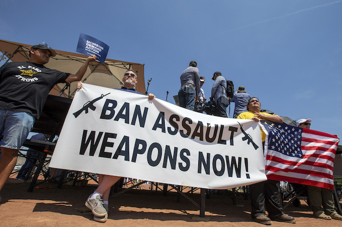 Manifestantes sostienen una pancarta para protestar por la visita del Presidente Donald Trump a la ciudad fronteriza el 7 de agosto de 2019 después del tiroteo masivo del 3 de agosto en El Paso, Texas.