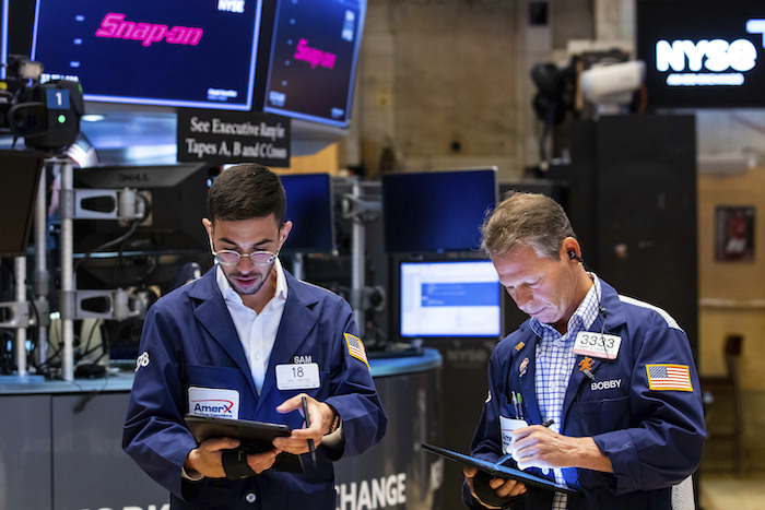 En esta fotografía proporcionada por la Bolsa de Valores de Nueva York, los corredores Orel Partush (izquierda) y Robert Charmak trabajan, el viernes 10 de junio de 2022.