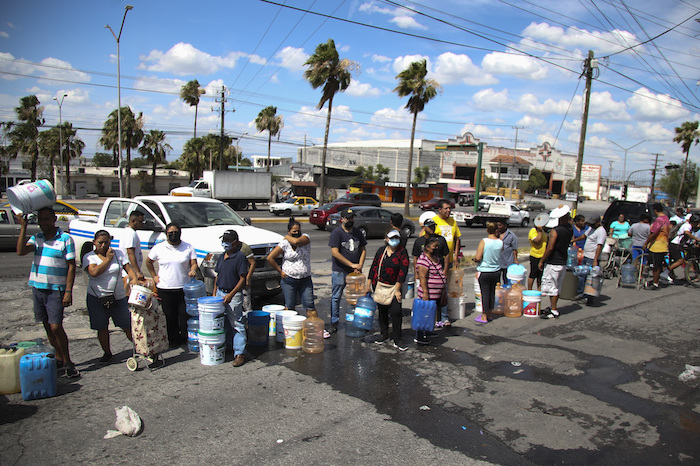 Vecinos llenan garrafas de plástico con agua en un punto de suministro público en Monterrey, México, el 20 de junio de 2022.