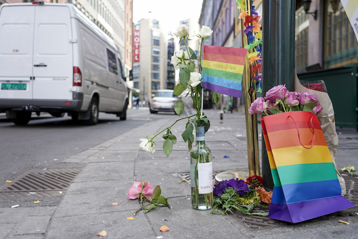 Flores acompañadas por los colores del orgullo gay yacen en el sitio donde un hombre armado se puso a disparar, el sábado 25 de junio de 2022, en el centro de Oslo. 