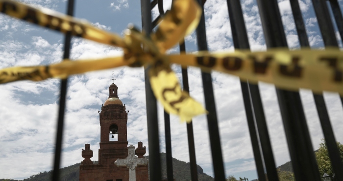 Una cinta policial acordona la escena del crimen en la iglesia de Cerocahui, México, el miércoles 22 de junio de 2022. Dos sacerdotes jesuitas fueron asesinados dentro de la iglesia, donde aparentemente buscó refugio un hombre perseguido por sujetos armados, anunció el martes la rama mexicana de la orden religiosa.