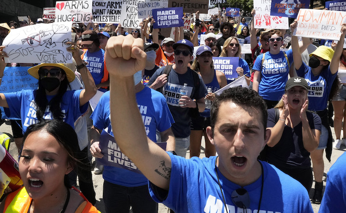 Badim Trubetskoy, de Boston y recién egresado de la Universidad del Sur de California, participa en la marcha para demandar leyes estrictas para el control de las armas de fuego, en el centro de Los Ángeles, el sábado 11 de junio de 2022.