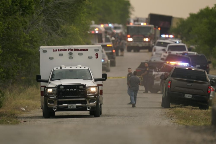 Una ambulancia sale del lugar donde la policía dijo que decenas de personas fueron encontradas muertas en un tráiler en un área remota en el suroeste de San Antonio, el lunes 27 de junio de 2022.