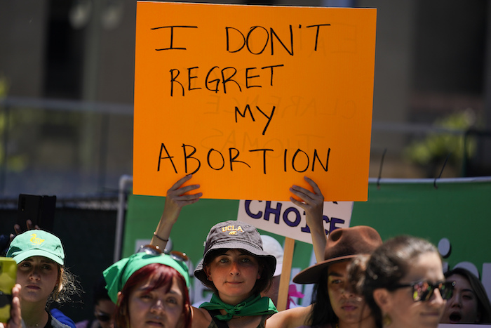 Una mujer sostiene un letrero frente a una corte federal para protestar por el fallo de la Corte Suprema de Estados Unidos sobre el aborto, el viernes 24 de junio de 2022, en Los Ángeles. El letrero dice: "No lamento mi aborto".