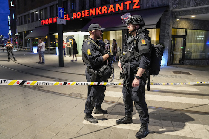 Dos policías vigilan el frente de un bar tras una balacera en el exterior que dejó dos muertos y más de una docena de heridos, el sábado 25 de junio de 2022, en el centro de Oslo, Noruega.