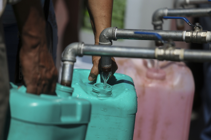 Vecinos llenan garrafas de plástico con agua en un punto de suministro público en Monterrey, México, el 20 de junio de 2022.