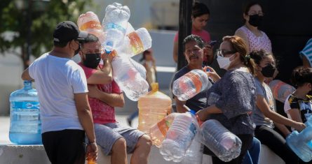 Vecinos esperan para llenar garrafas de plástico con agua en un punto de suministro público en Monterrey, México, el 20 de junio de 2022.