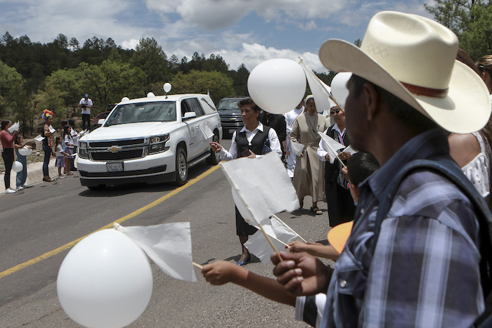 Los vecinos reciben la procesión fúnebre de los sacerdotes jesuitas Javier Campos y Joaquín Mora en Cerocahui, estado de Chihuahua, México, el domingo 26 de junio de 2022.