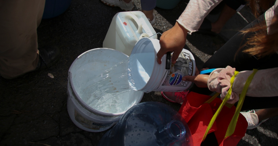 Vecinos llenan garrafas de plástico con agua en un punto de suministro público en Monterrey, México, el 20 de junio de 2022.