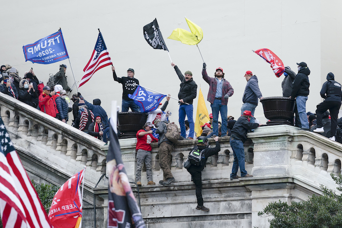 Una turba agita banderas frente al Capitolio, en Washington, el 6 de enero de 2021. A medida que se desvanece la confianza en las instituciones de la democracia, florecen las teorías conspirativas.