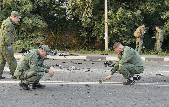 Imagen tomada de un video publicado por el Comité de Investigación ruso el domingo 21 de agosto de 2022, en la que los investigadores trabajan en el lugar de la explosión de un coche conducido por Darya Dugina en las afueras de Moscú. 