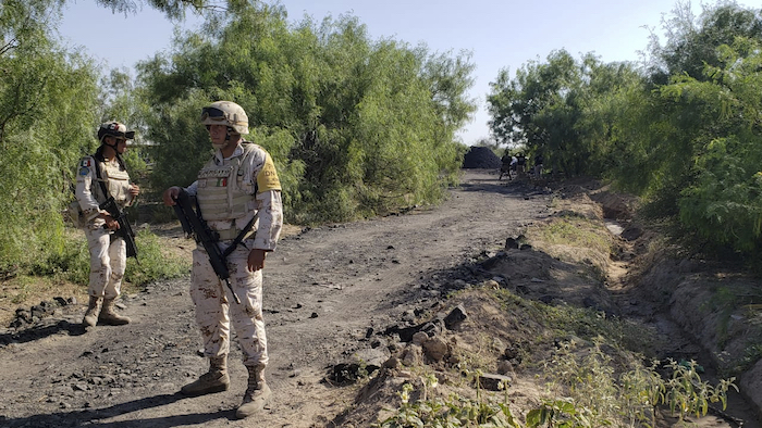 La Guardia Nacional se encuentra a lo largo de la carretera que conduce a donde mineros están atrapados en una mina de carbón colapsada e inundada en Sabinas, en el estado mexicano de Coahuila, el jueves 4 de agosto de 2022.