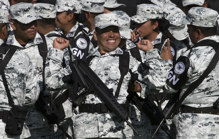 Un miembro de la Guardia Nacional sonríe mientras se estira antes del inicio de una ceremonia de presentación en un campo militar en Ciudad de México, el 30 de junio de 2019.