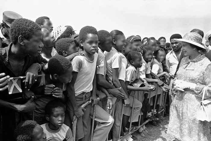 Escolares jamaicanos saludan a la reina Isabel II en el Monumento de los Héroes Nacionales en Kingston, Jamaica, el 14 de febrero de 1983, en el segundo día de la visita de la reina a la excolonia británica.