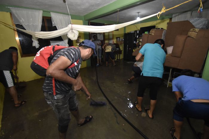 Habitantes de Tixtla afectados por "Lester" tratan de sacar el agua de sus casas.