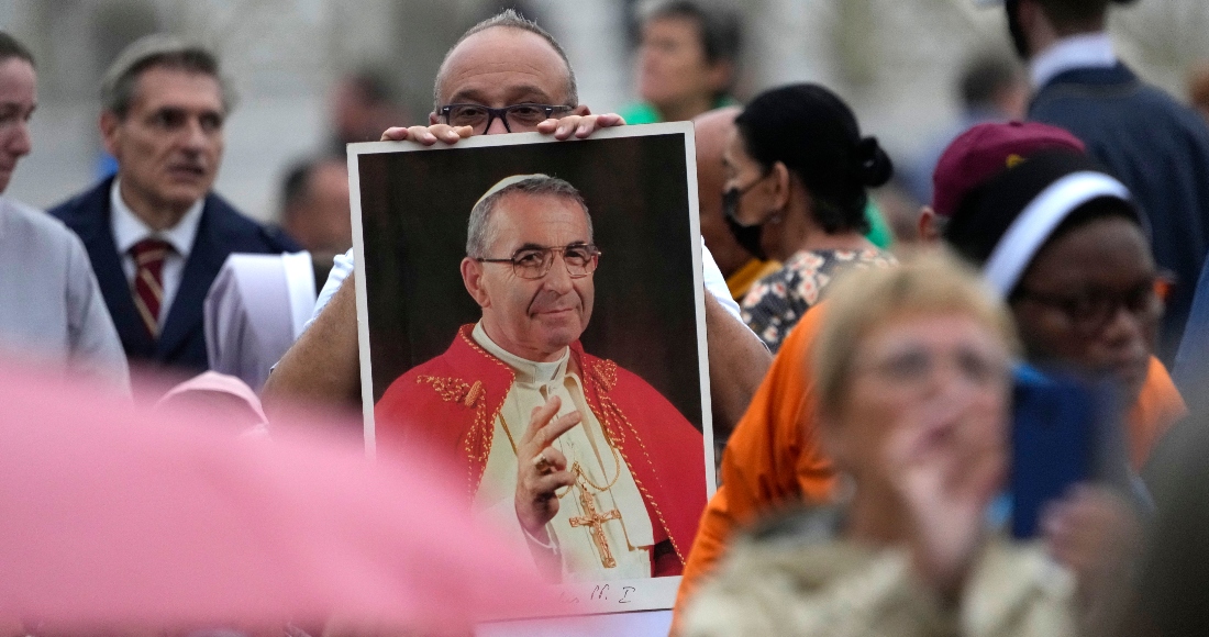 Un hombre sostiene una foto del Papa Juan Pablo I durante una ceremonia de beatificación dirigida por el Papa Francisco en la Plaza de San Pedro del Vaticano.