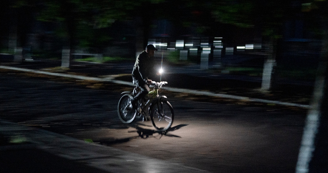 Un hombre viaja en bicicleta por la calle antes de un toque de queda el domingo 4 de septiembre de 2022, en Pokrovsk, Ucrania.