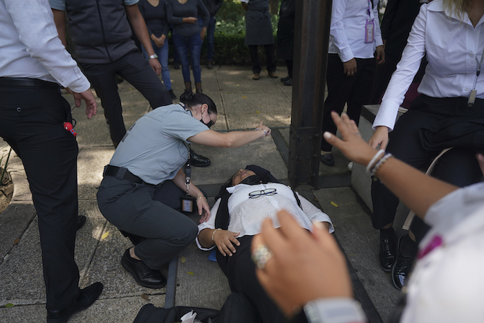 Una mujer es asistida por ansiedad mientras la gente se reúne en la calle luego de un terremoto de magnitud 7.7 en la Ciudad de México, el lunes 19 de septiembre de 2022.