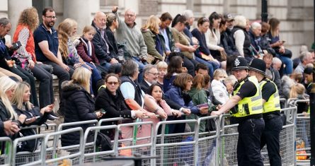 Varias personas esperan antes del paso del cortejo fúnebre de la reina Isabel II desde el Palacio de Buckingham a Westminster, en Westminster, en el centro de Londres, el 14 de septiembre de 2022.