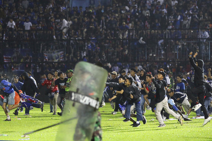 Aficionados al futbol corren durante una serie de enfrentamientos en Malang, Indonesia, el sábado 1 de octubre de 2022.