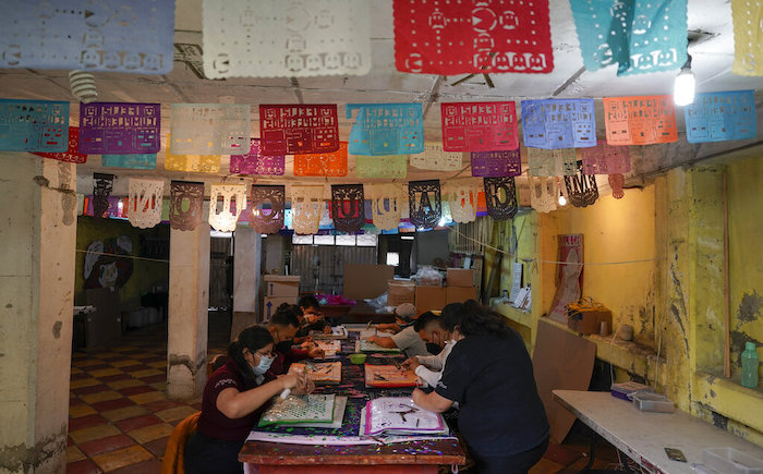 Artesanos elaboran "papel picado", adornos recortados de papel que se usa desde hace mucho tiempo en los altares del Día de Muertos, en un taller en Xochimilco, una delegación de la Ciudad de México, el jueves 27 de octubre de 2022.