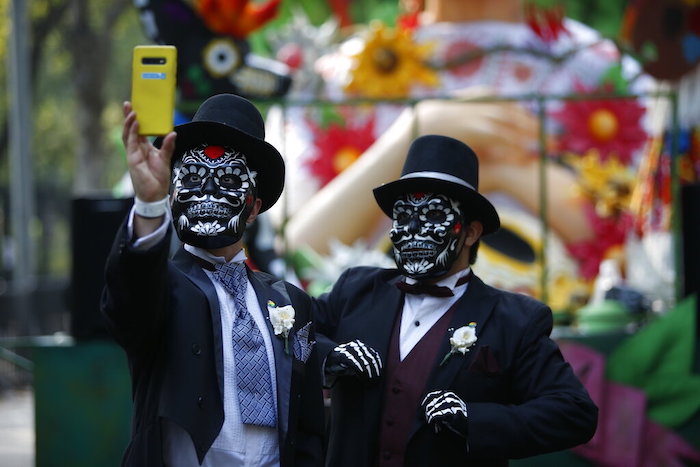 Gabino Pacheco se toma una foto junto a su esposo David Pacheco durante el desfile del Día de Muertos en la Ciudad de México, el sábado 29 de octubre de 2022.