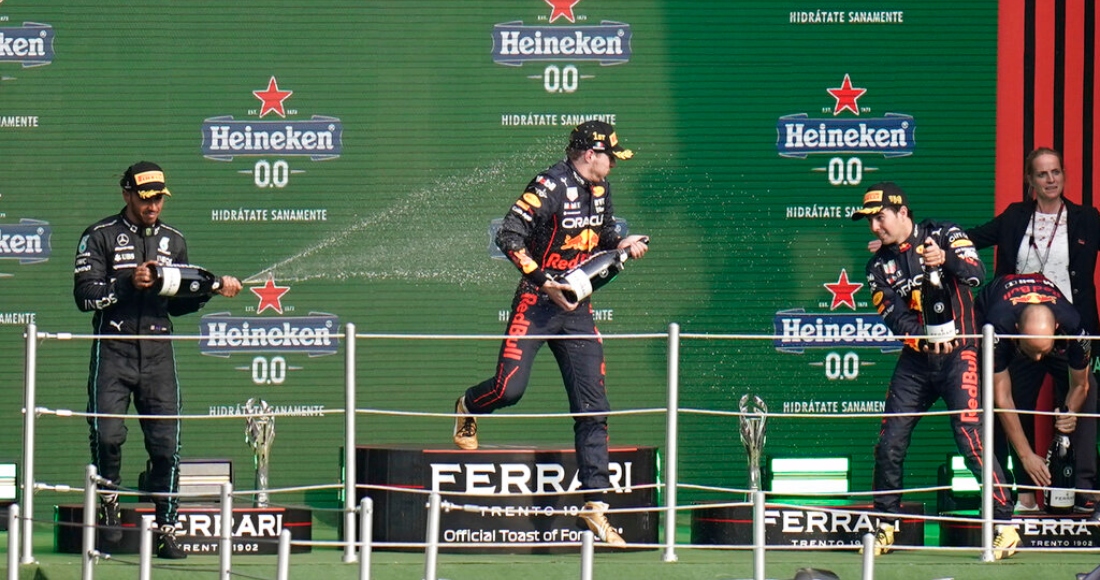 El británico Lewis Hamilton, izquierda, de Mercedes; el holandés Max Verstappen, centro, de Red Bull; y el mexicano Sergio Pérez, de Red Bull, festejan en el podio después del Gran Premio de México de la Fórmula Uno, en el Autódromo Hermanos Rodriguez de Ciudad de México, el domingo 30 de octubre de 2022.