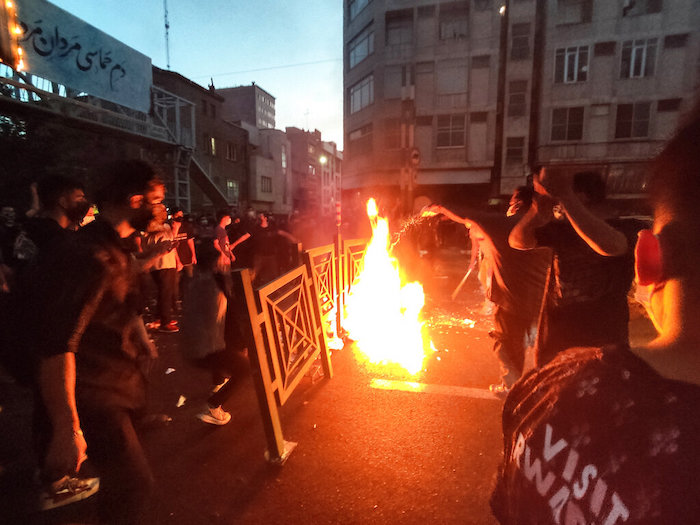 En esta foto del 21 de septiembre de 2022, tomada por una persona no empleada por "The Associated Press" y obtenida por AP fuera de Irán, manifestantes encienden una fogata y bloquean la calle durante una marcha de protesta por la muerte de una joven detenida por la policía.