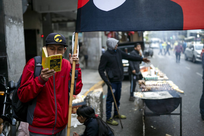 Marcos Tend lee "1984" de George Orwell mientras participa en una protesta junto con trabajadores de la fabricación de neumáticos que exigen un aumento salarial frente al Ministerio del Trabajo en Buenos Aires, Argentina, el jueves 29 de septiembre de 2022.