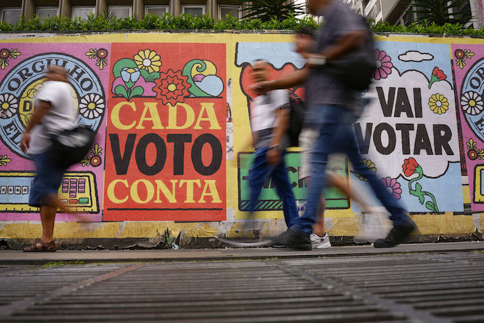 Personas caminan frente a un mural con el mensaje "Cada voto cuenta", en Sao Paulo, Brasil, el 25 de octubre de 2022.