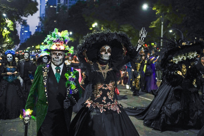 Personas vestidas como las icónicas "Catrinas" de México marchan en la Gran Procesión de las Catrinas, parte de las celebraciones del Día de Muertos en la Ciudad de México, el domingo 23 de octubre de 2022.