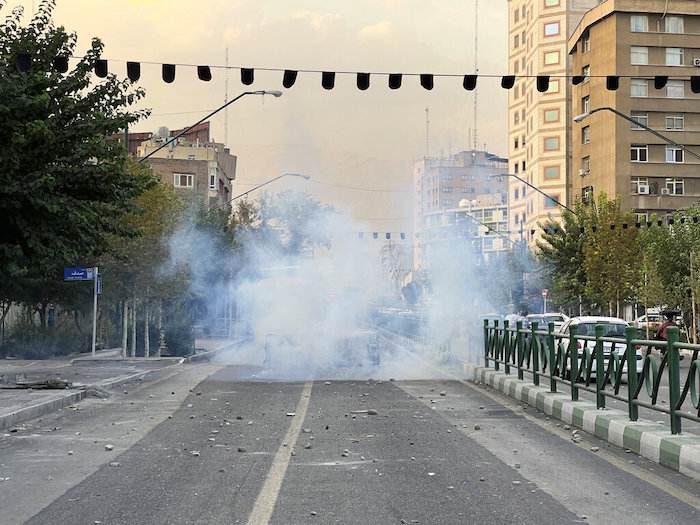 En esta foto del martes 20 de septiembre de 2022, tomada por una persona que no trabaja para "Associated Press" y que fue obtenida por la AP fuera de Irán, la policía lanza gases lacrimógenos durante una protesta por la muerte de una joven que había sido detenida por violar el código de vestimenta conservador del país, en el centro de Teherán, Irán.