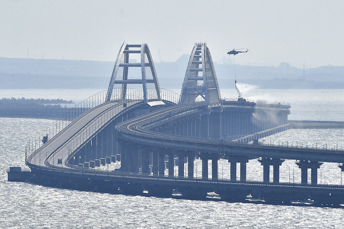 Un helicóptero arroja agua sobre un puente para sofocar un incendio, en el puente que conecta la península de Crimea con el territorio continental ruso sobre el estrecho de Kerch, en Kerch, el 8 de octubre de 2022.