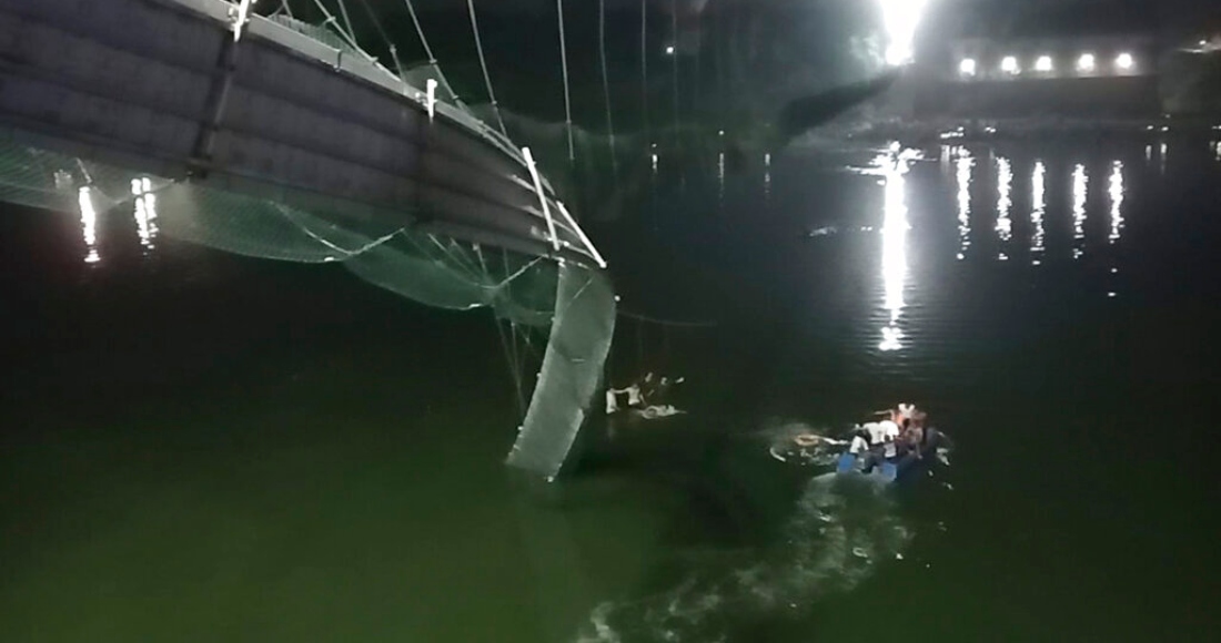 Rescatistas en botes buscan a personas en el río Machchu debajo de un puente de cable que se derrumbó en el distrito de Morbi, India, el domingo 30 de octubre de 2022.