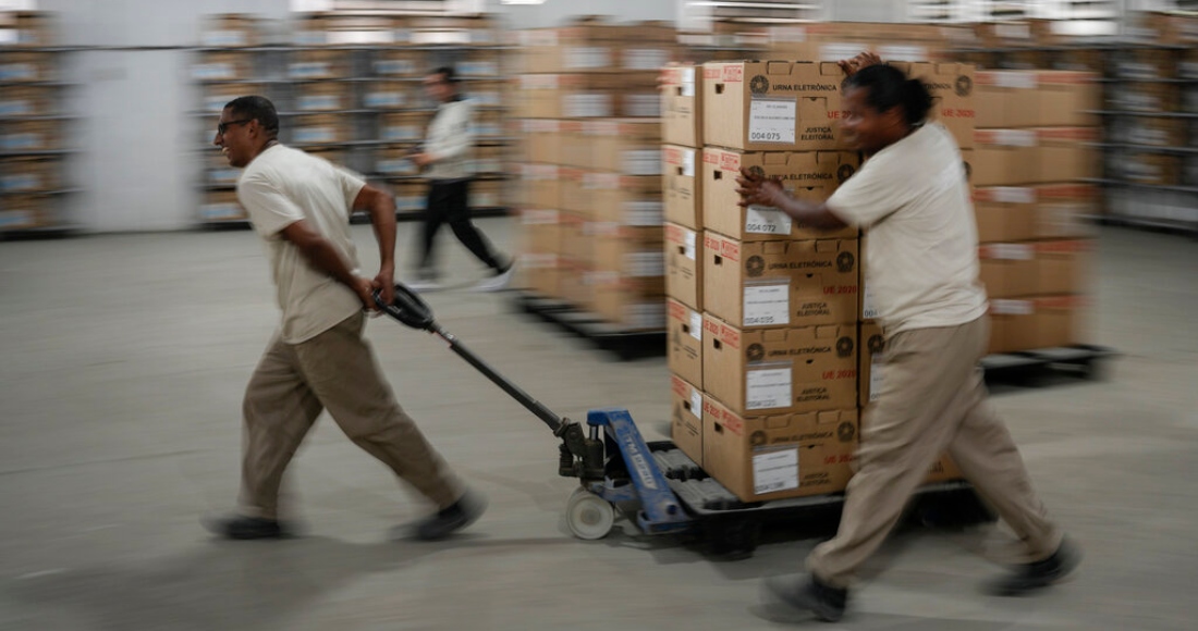 Trabajadores electorales trasladan máquinas de voto electrónico en un centro de distribución en Río de Janeiro, Brasil, el sábado 1 de octubre de 2022.