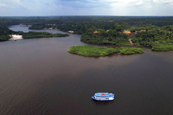 Trabajadores electorales y policías militares llegan en bote a Bela Vista do Jaraqui, en Manaos, Brasil, con equipo para un centro de votación un día antes de las elecciones generales del país, el 1 de octubre de 2022.