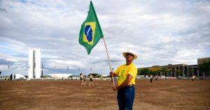 Un partidario del Presidente Jair Bolsonaro, que aspira a ser reelegido, sostiene una bandera de Brasil tras el cierre de las urnas en la segunda vuelta electoral, el domingo 30 de octubre de 2022, en Brasilia, Brasil.